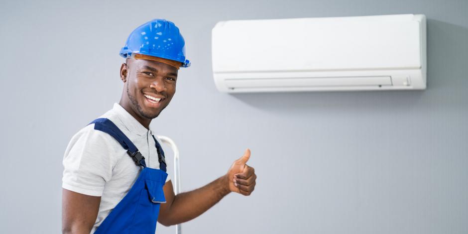 Technician Giving A Thumbs Up In Front Of A Mini-Split Heat Pump