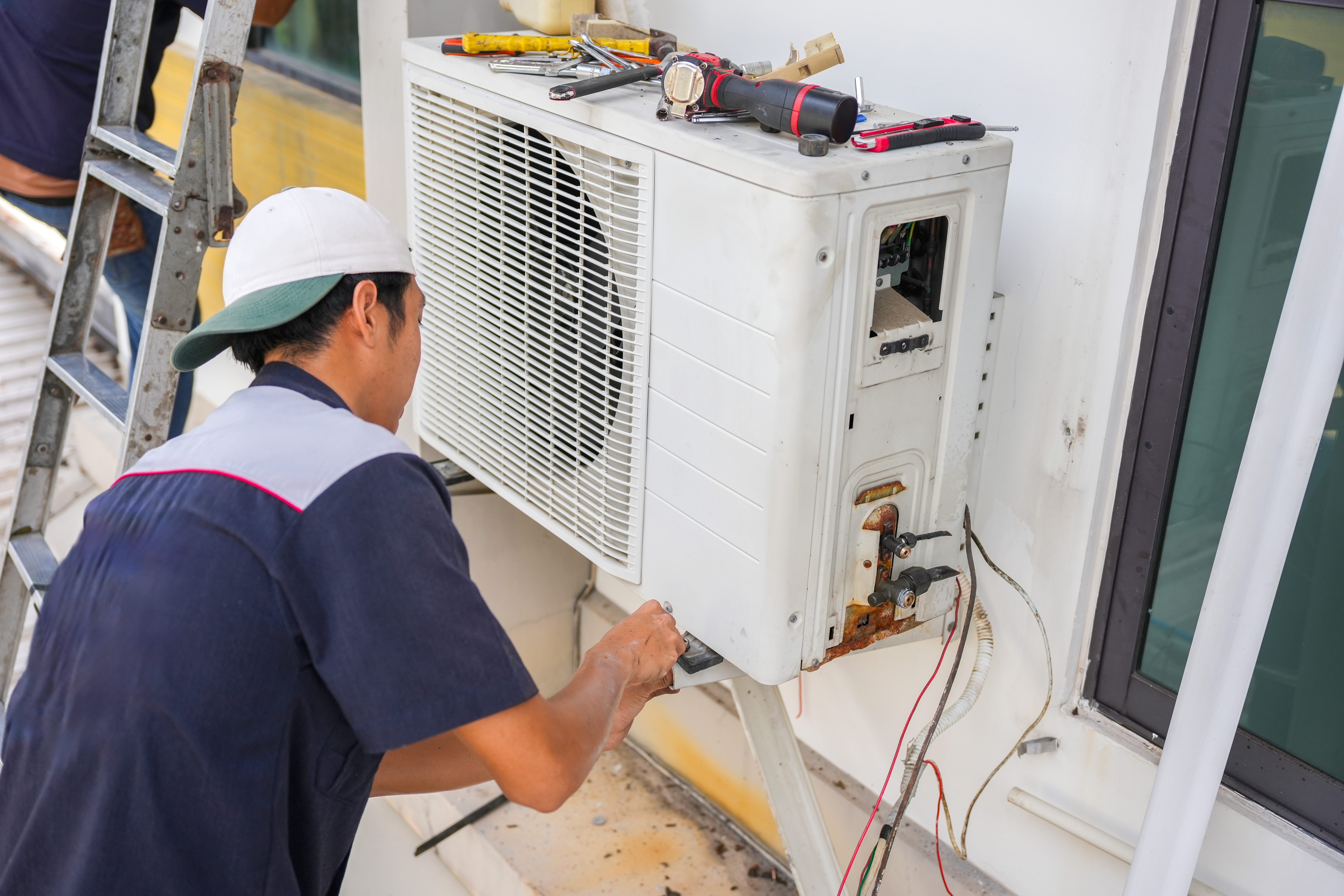 man working on a heat pump